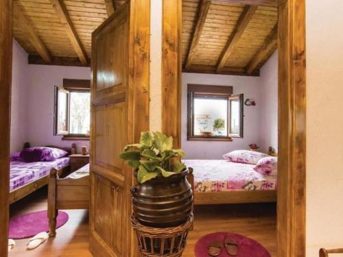 a bedroom with two beds and a potted plant at Three bedroom Vila with Pool in Stankovci