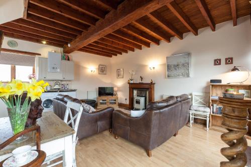 a living room with two couches and a kitchen at Skipbridge Farm Cottages in Green Hammerton