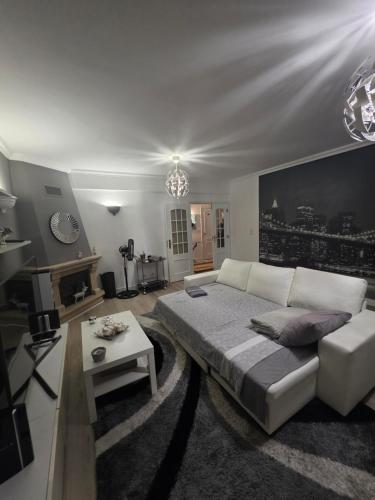 a living room with a large bed and a couch at Apartamento para 6 hóspedes em Queluz próximo Lisboa,Sintra e Cascais in Queluz