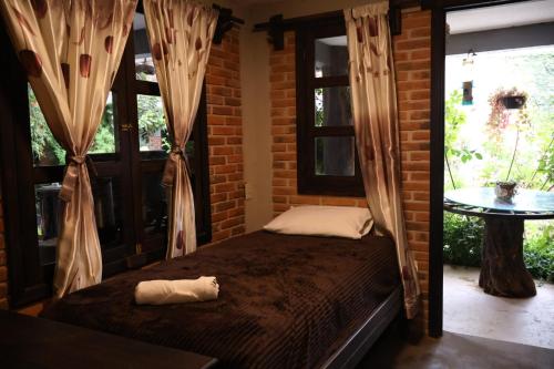 a bedroom with a bed in a room with windows at Hotel las carretas , spa y temazcal in Zacatlán