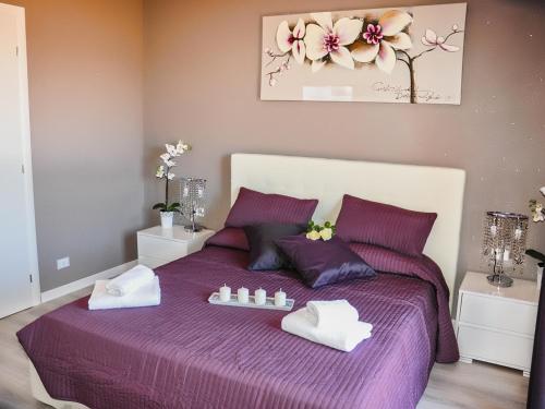 a bedroom with a purple bed with towels on it at Villa Erasi in Fiumicino