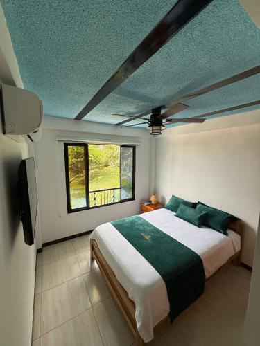 a bedroom with a large bed and a window at Cristo Rey Hostal Campestre Cali in Cali