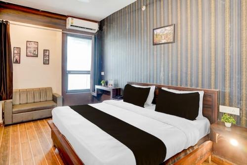 a bedroom with a large bed and a couch at Raj Embassy in Rudrapur