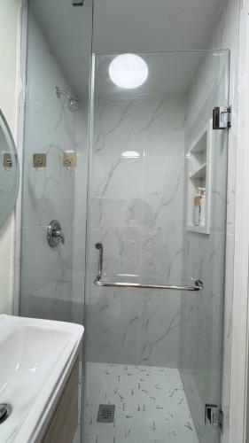 a shower with a glass door in a bathroom at Cozy room with private bathroom near subway in Toronto