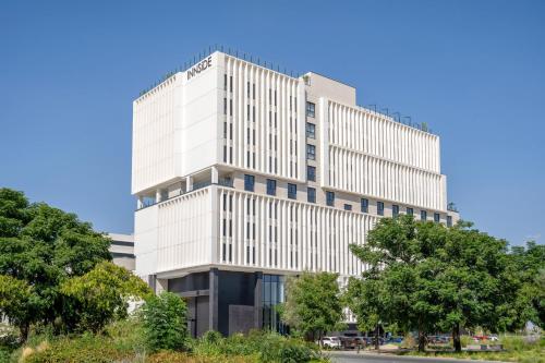a tall white building with trees in front of it at INNSiDE by Meliá Madrid Valdebebas in Madrid