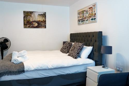 a bedroom with a bed with white sheets and pillows at Charles House in Chatham