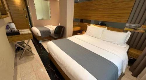 a hotel room with a large bed and a desk at Hong Thai Hotel in Macau