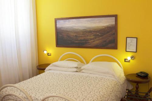 a bedroom with a bed with a painting on the wall at Hotel Pallotta in Assisi