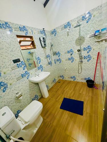 a bathroom with a shower and a toilet and a sink at Priyavimana resort in Habarana