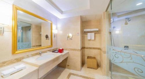 a bathroom with a sink and a shower and a mirror at Regency Hotel in Dongguan