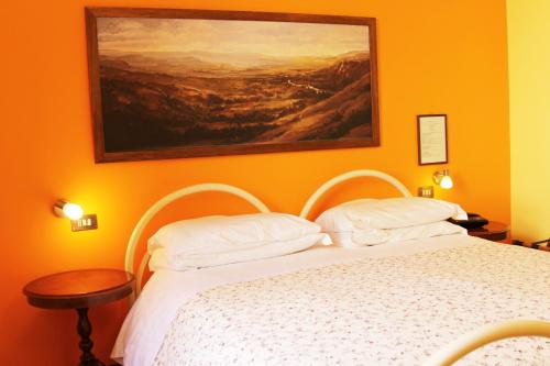 a bedroom with a bed with a painting on the wall at Hotel Pallotta in Assisi