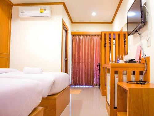a hotel room with two beds and a television at Loei Residence in Ban Tha Phae
