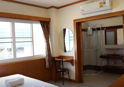 a bedroom with a bed and a sink and a mirror at Loei Residence in Ban Tha Phae