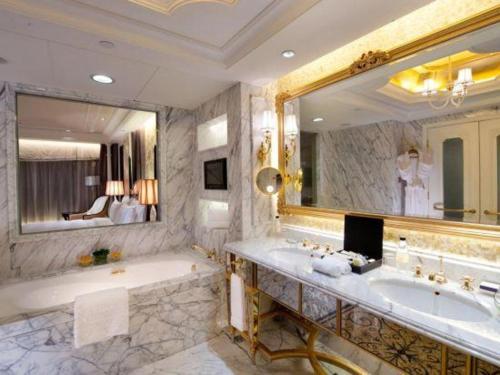 a bathroom with a tub and a large mirror at L'Arc Hotel Macau in Macau