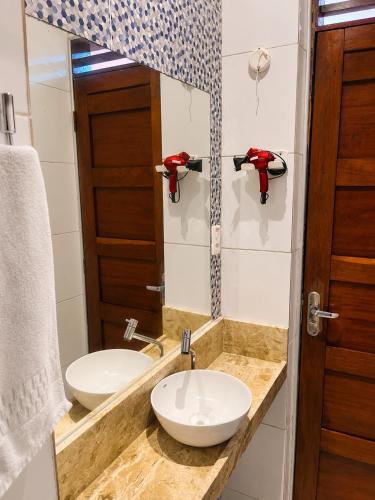 a bathroom with a sink and a mirror at Pousada La Riviera - Pé na areia e Passeios em Maragogi in Maragogi