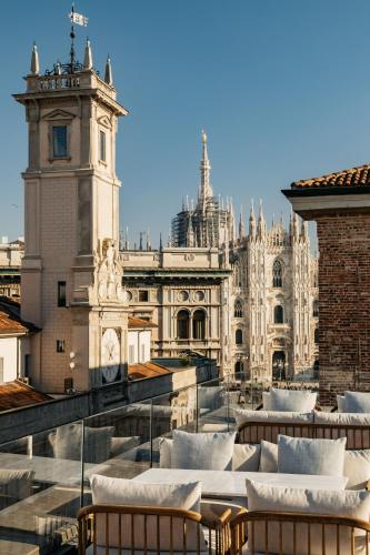 a view of a building with chairs and a clock tower at Palazzo Cordusio, a Gran Meliá Hotel - The Leading Hotels of the World in Milan