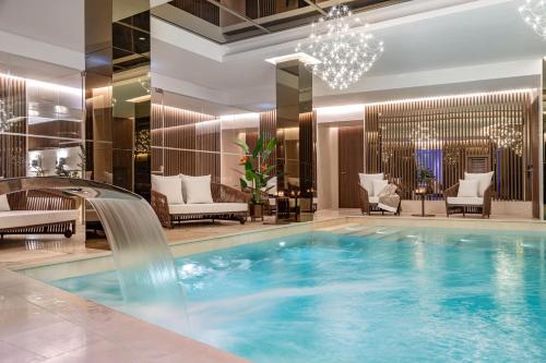 a pool with a waterfall in a hotel lobby at Palazzo Cordusio, a Gran Meliá Hotel - The Leading Hotels of the World in Milan