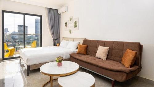 a living room with a couch and a bed and a table at Riverside Studio - Yuetai Phnom Penh in Phnom Penh