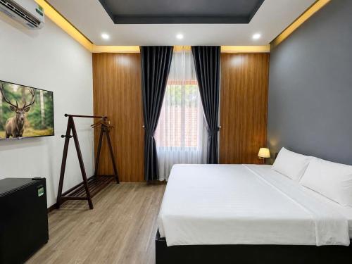 a bedroom with a white bed and a window at Lion Homestay Huế in Thôn Lại Thê