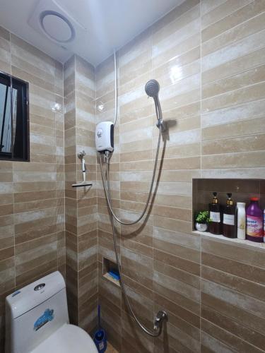 a shower in a bathroom with a toilet at IBM Homestay in Butuan