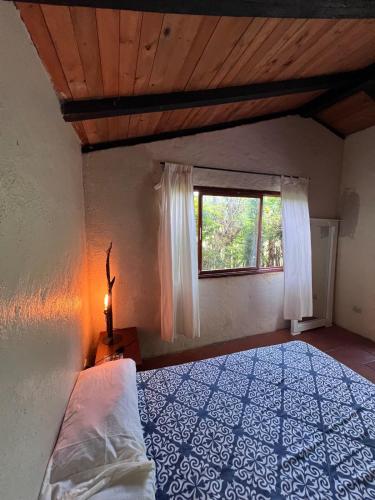 a bedroom with a bed and a window at Casa del Río, Vilcabamba in Loja