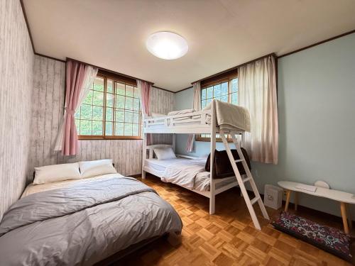 a bedroom with two beds and a bunk bed at Guest house AZSINN in Ueda