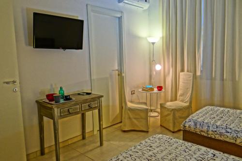 a hotel room with a bed and a television on the wall at B&B Liberty in Santa Maria Capua Vetere