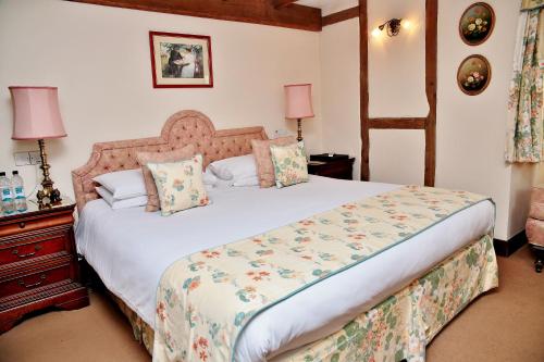 a bedroom with a large bed and a dresser at The Inglenook Hotel in Bognor Regis