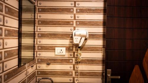 a phone is on the side of a wall at Harshavardhana Inn in Kizhake Chālakudi