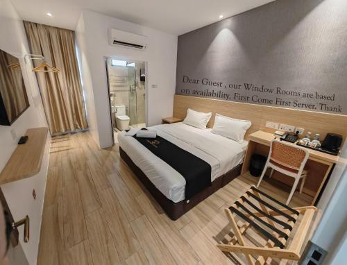 a hotel room with a bed and a desk with a desk at V Boutique Hotel Seremban in Seremban