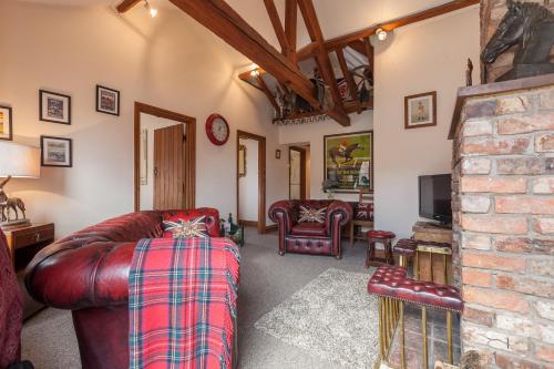 a living room with a couch and a tv at Skipbridge Farm Cottages in Green Hammerton