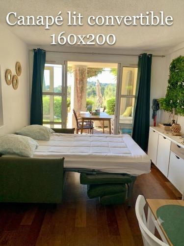 a room with two beds in a room with a table at Appartement Premium Genius - Chambre séparée -vue Mer -Jardin Clôturé -Terrasse -Parking - Piscine Chauffée du 04 Avril au 01 Novembre- Saint Raphaël in Agay - Saint Raphael
