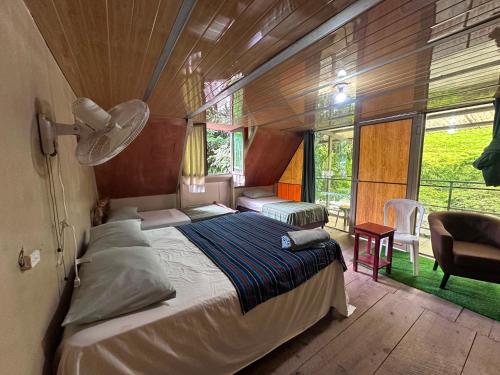 a bedroom with a bed and a large window at Yaxlik River Lodge in Lanquín