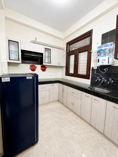 a kitchen with a black refrigerator in the middle at Luxury Airy Retreat in Jaipur