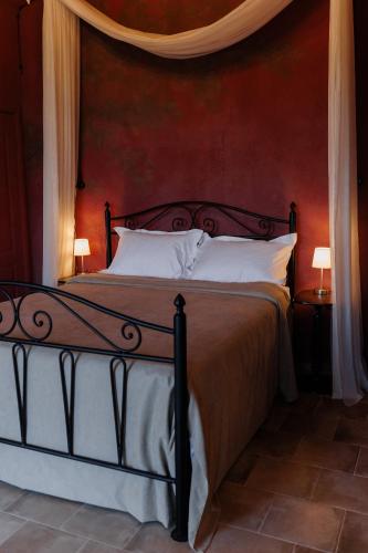 a bedroom with a bed with a red wall at KISLOV Vineyard Boutique Hotel in Hagimus