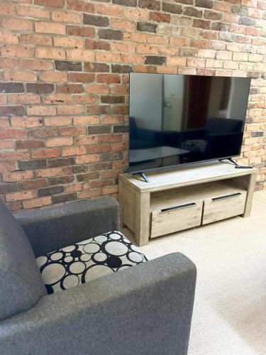 a living room with a couch and a television at Speers Point Serviced Apartments in Cockle Creek
