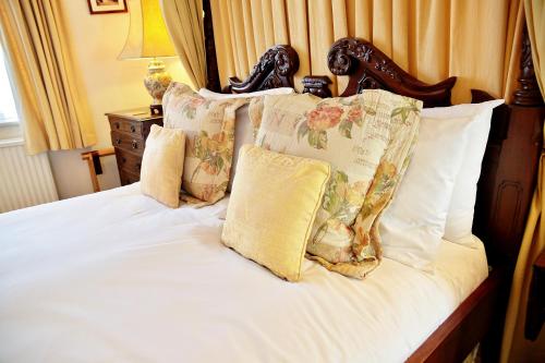 a bed with white sheets and pillows at The Inglenook Hotel in Bognor Regis