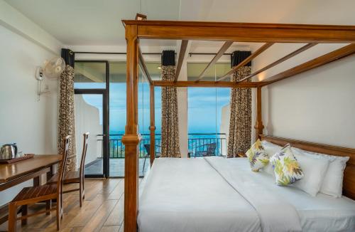 a bedroom with a bed with a view of the ocean at Leisure Mount Villa in Haputale