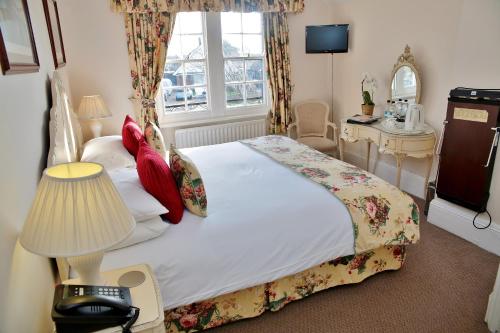 a bedroom with a large bed and a window at The Inglenook Hotel in Bognor Regis