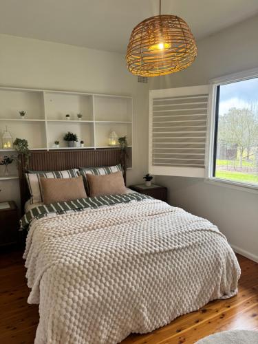 a bedroom with a large bed and a window at The Thirlmere Homestead in Thirlmere