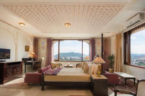 a bedroom with a bed and a large window at Raj Kuber - A Boutique Lake View Hotel in Udaipur