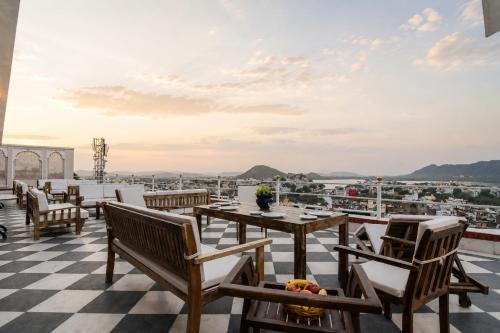 a restaurant with a checkered floor and tables and chairs at Raj Kuber - A Boutique Lake View Hotel in Udaipur