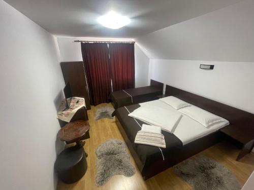 a small room with a bed with white sheets at Pensiunea Sonia in Cârțișoara