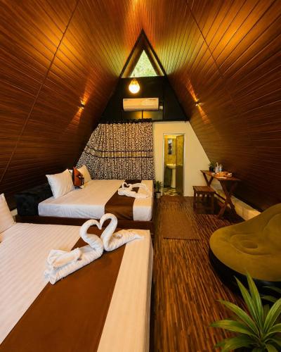 a hotel room with two beds with towels on them at Elephant Cabana Udawalawe in Udawalawe