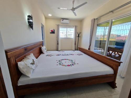 a bed in a room with a window at BazarBe Appartment in Nosy Be