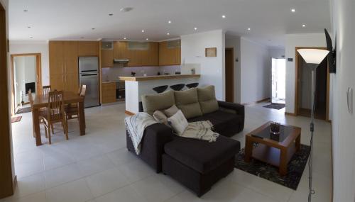 ein Wohnzimmer und eine Küche mit einer Couch und einem Tisch in der Unterkunft Cantinho da Ilha in Achadinha