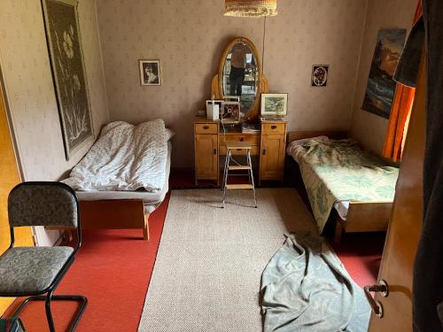 a small room with two beds and a mirror at Vanha maatilanpihapiiri Patula in Pertunmaa