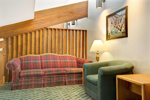 a living room with a couch and a chair at Travelodge by Wyndham Valleyfair Shakopee in Shakopee