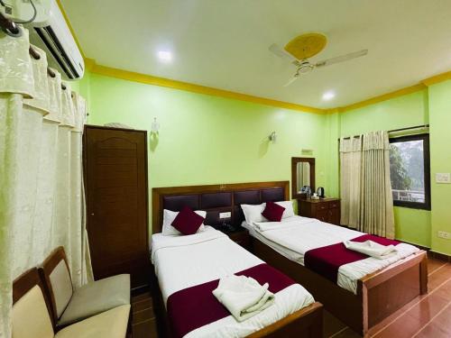 a hotel room with two beds and a chair at Hotel Buddha Palace in Rummindei