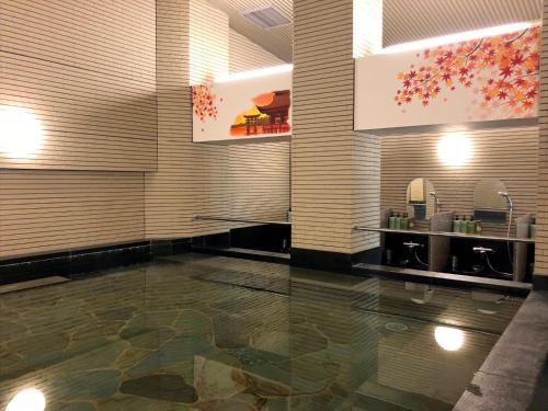 a lobby with a marble floor and paintings on the wall at Hotel Hokke Club Hiroshima in Hiroshima